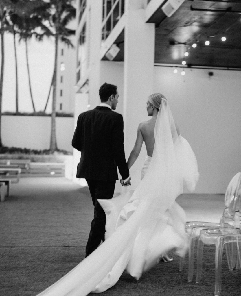 bride and groom walking into their cocktail hour