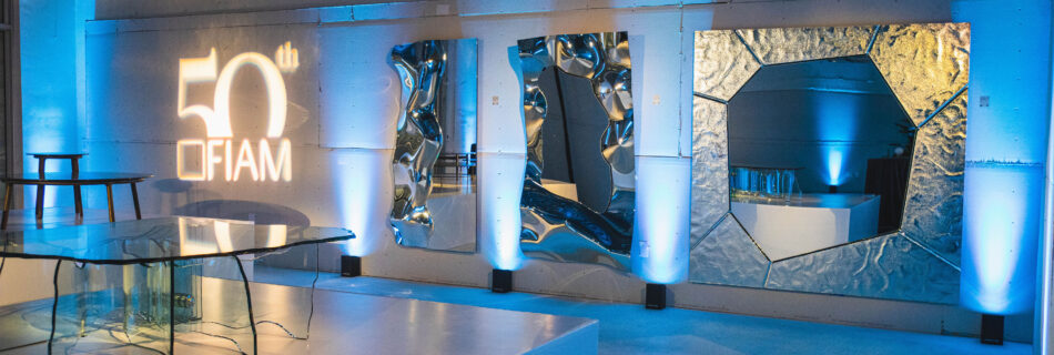 General shot of the art gallery showroom venue with blue lights displaying glass pieces.