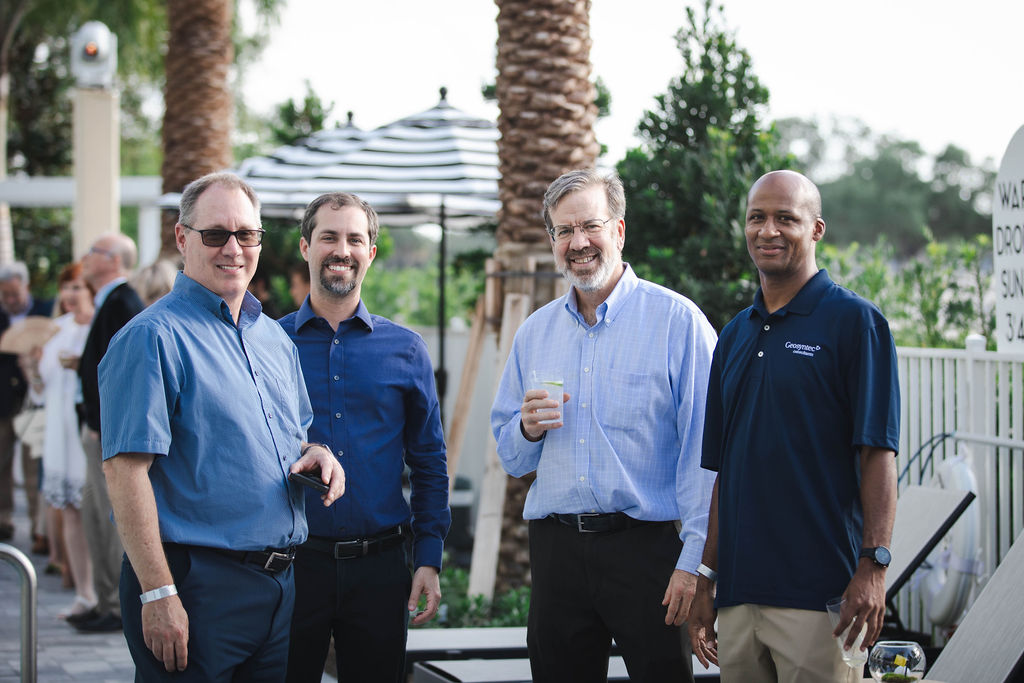 Four guests staring at the photographer while sipping a drink